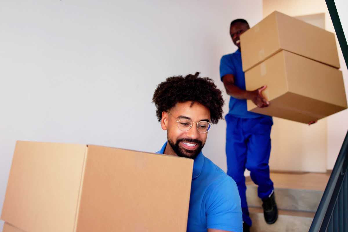 Movers Carrying Boxes On Residential Well Well Stairs