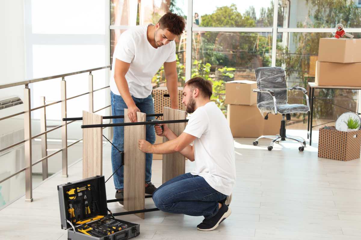 Professional workers disassembling rack in office. Moving service