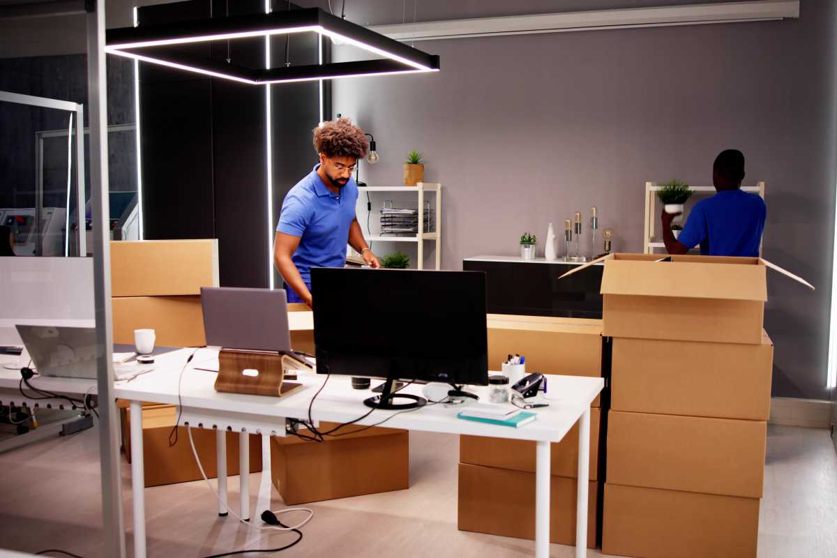 Professional Movers Packing Boxes In Modern Office