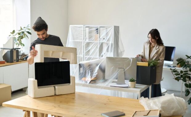 Employees Unpacking Boxes In Their New Office