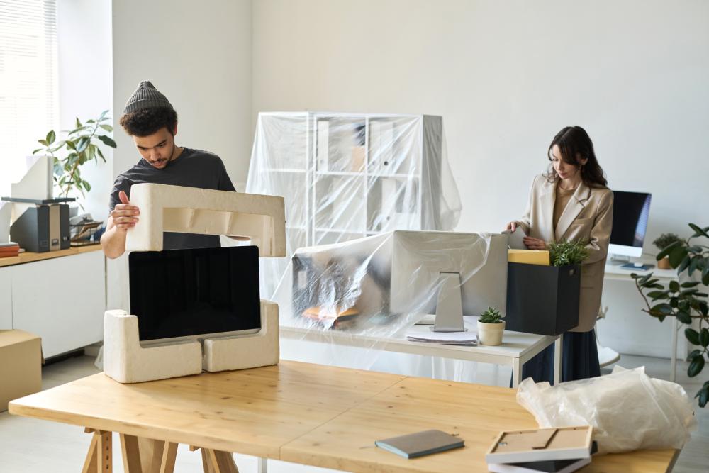 Employees Unpacking Boxes In Their New Office