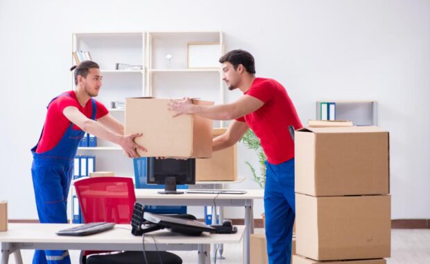 Professional Office Movers Handing Boxes To One Another