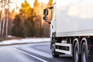 delivery truck driving on scenic rural road with beautiful natural landscape in background