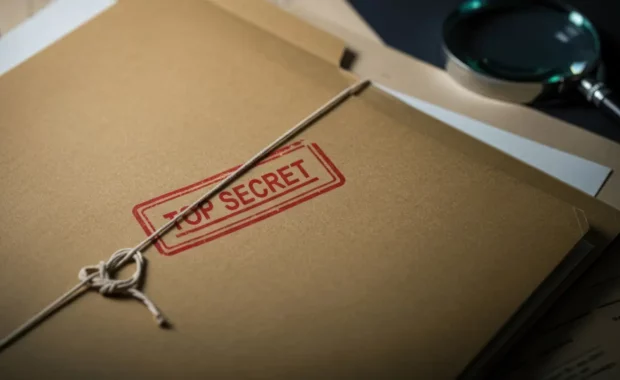 mysterious top secret folder surrounded by documents and a magnifying glass in a dimly lit room
