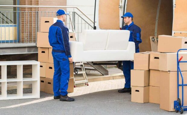 movers carrying sofa outside truck on street