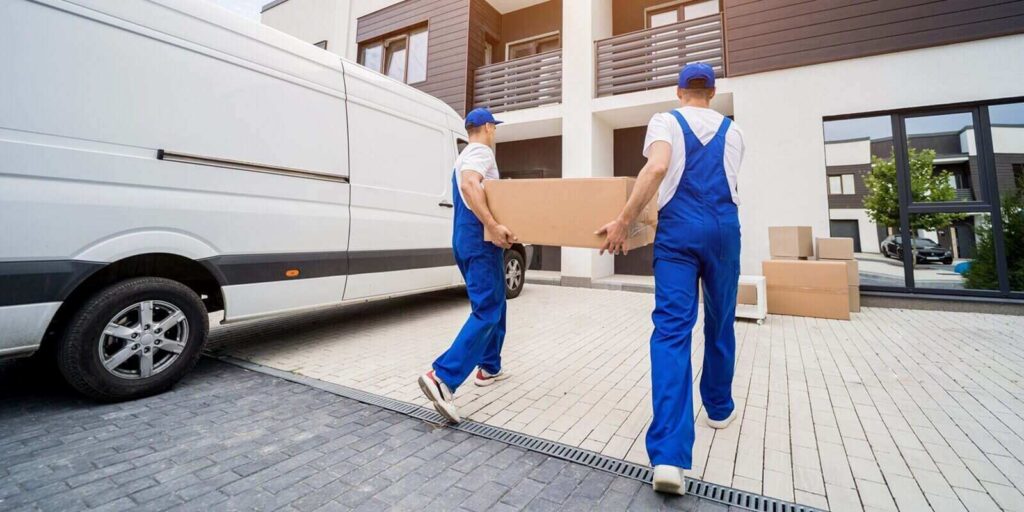 removal company workers unloading boxes and furniture from minibus