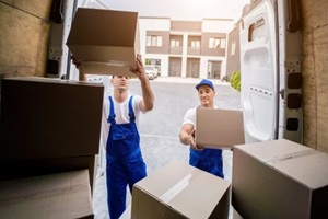 two removal company workers unloading boxes from minibus
