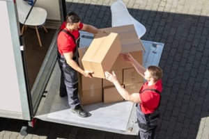 male movers unloading the cardboard boxes form truck