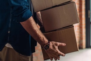 panoramic crop of businessman holding boxes and moving in new office