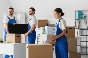female asian loader carrying box in office on moving day