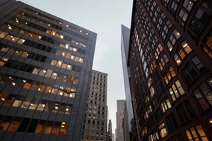 overcast morning tiltup of skyscrapers, glass curtain walls and vintage brick facades, office lights still glowing