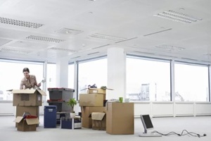 young businesswoman unpacking cartons in an empty office space
