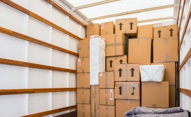 inside of a removal van, showing fabric blankets stacked and a background of cardboard boxes - climate-controlled storage for businesses